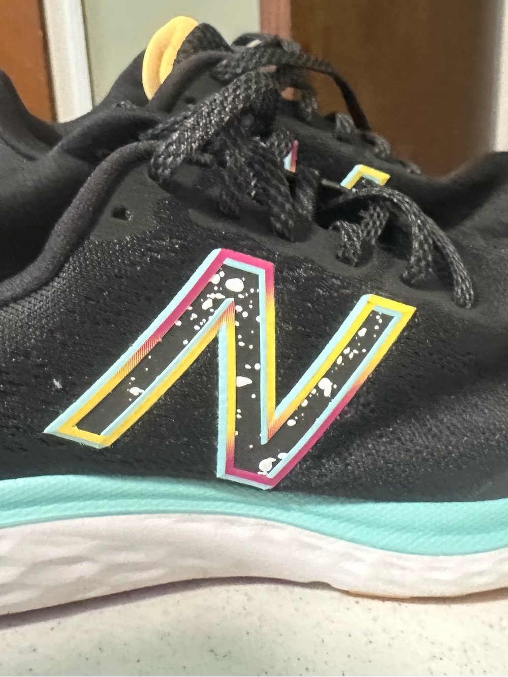 New Balance Black Athletic Shoes with Teal, Yellow and Pink Logo Accents